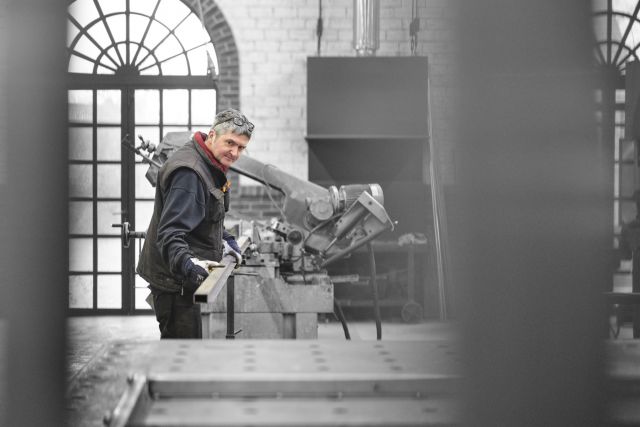 Marco werkt in de staalatelier aan een stalen deur.